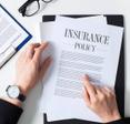 Business woman examining an insurance policy on her desk.