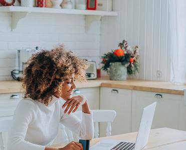 woman looking at laptop with credit card in hand