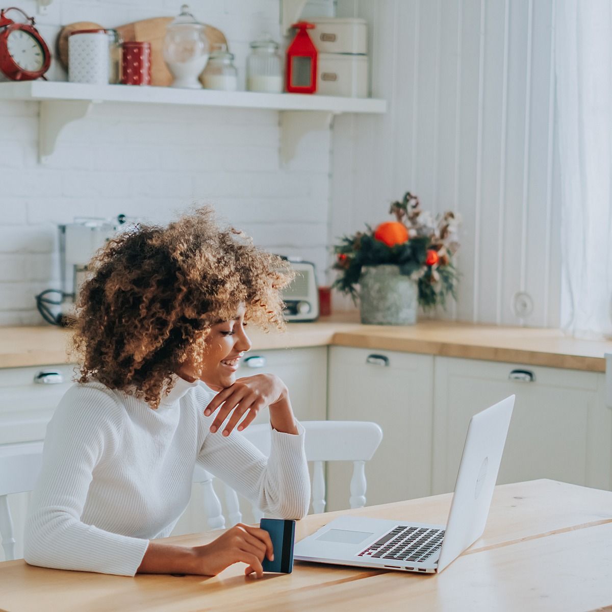 woman looking at laptop with credit card in hand