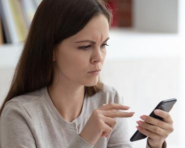 Woman looking upset at phone