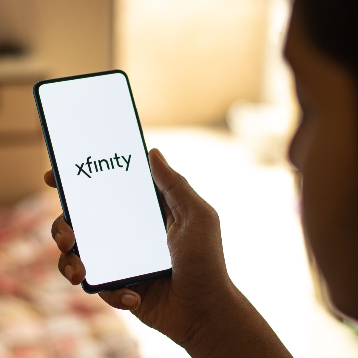 Person holding phone on the screen Xfinity logo